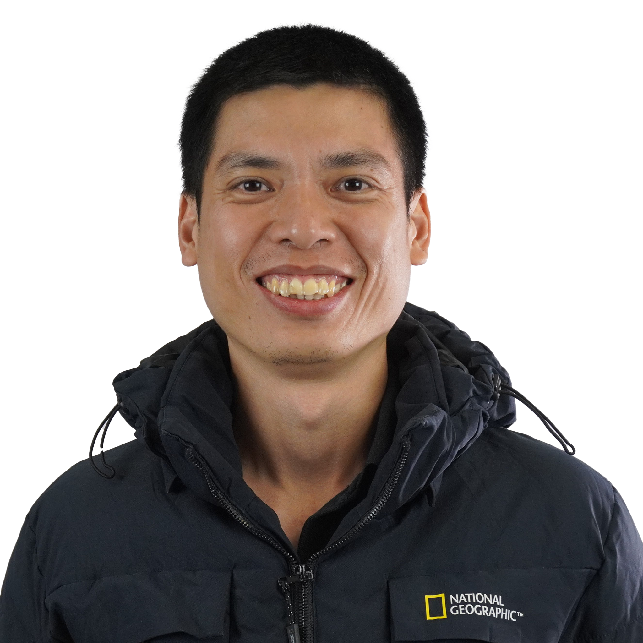 Close-up of a smiling man with short black hair wearing a black jacket with a National Geographic logo.