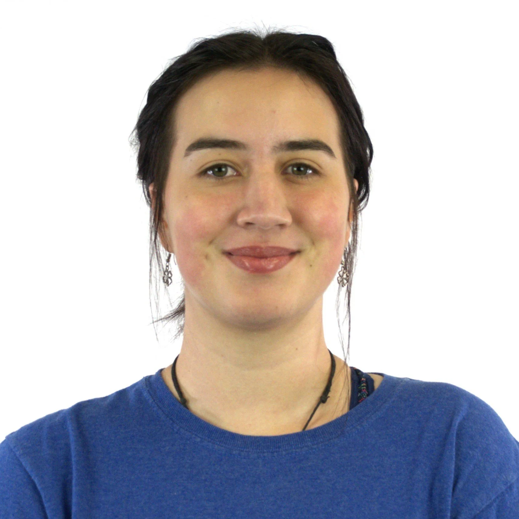 A young woman with short dark hair, wearing a blue shirt and a black necklace, smiling against a plain white background.