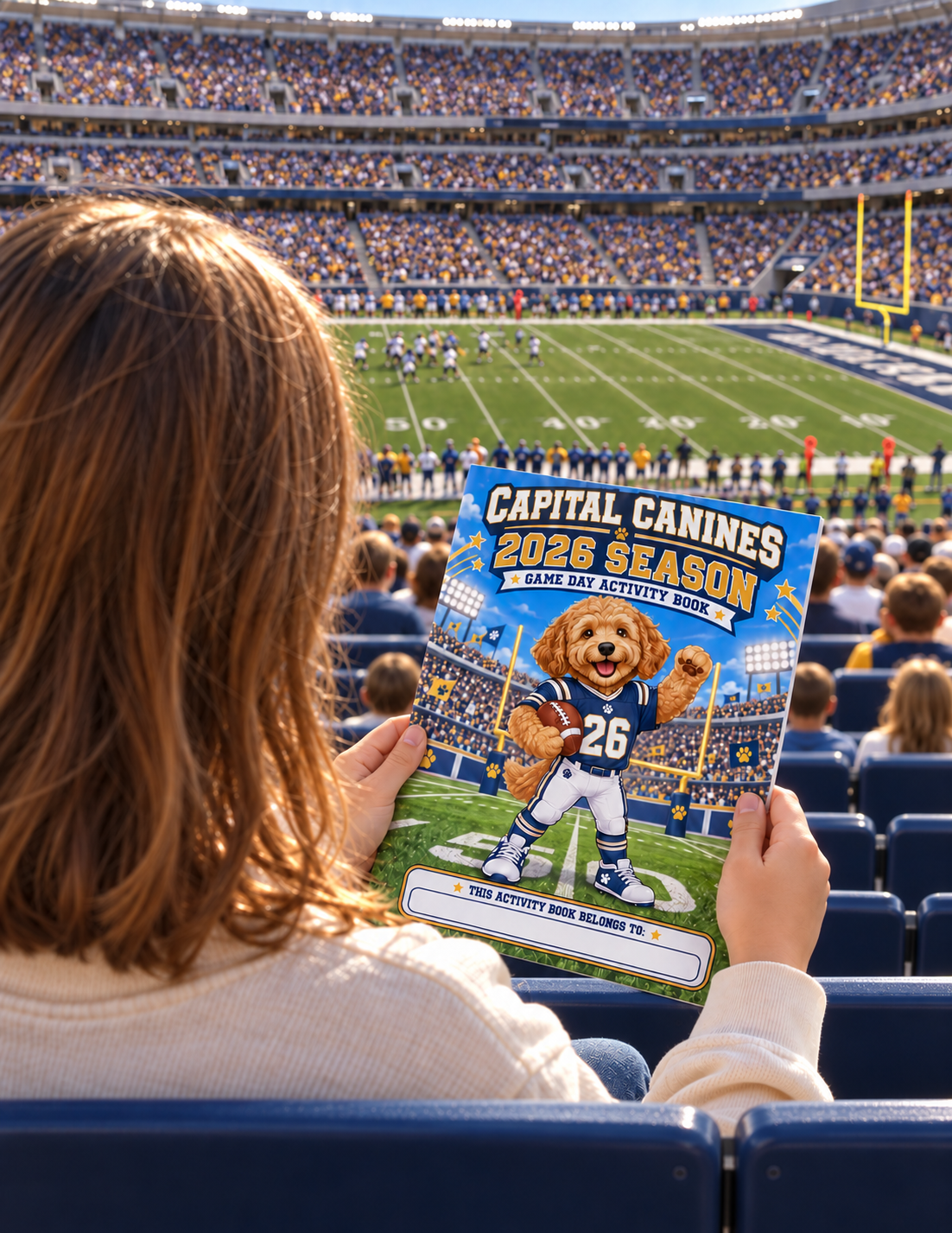 Child holding a custom Capital Canines football activity book while watching a game from the stadium stands.