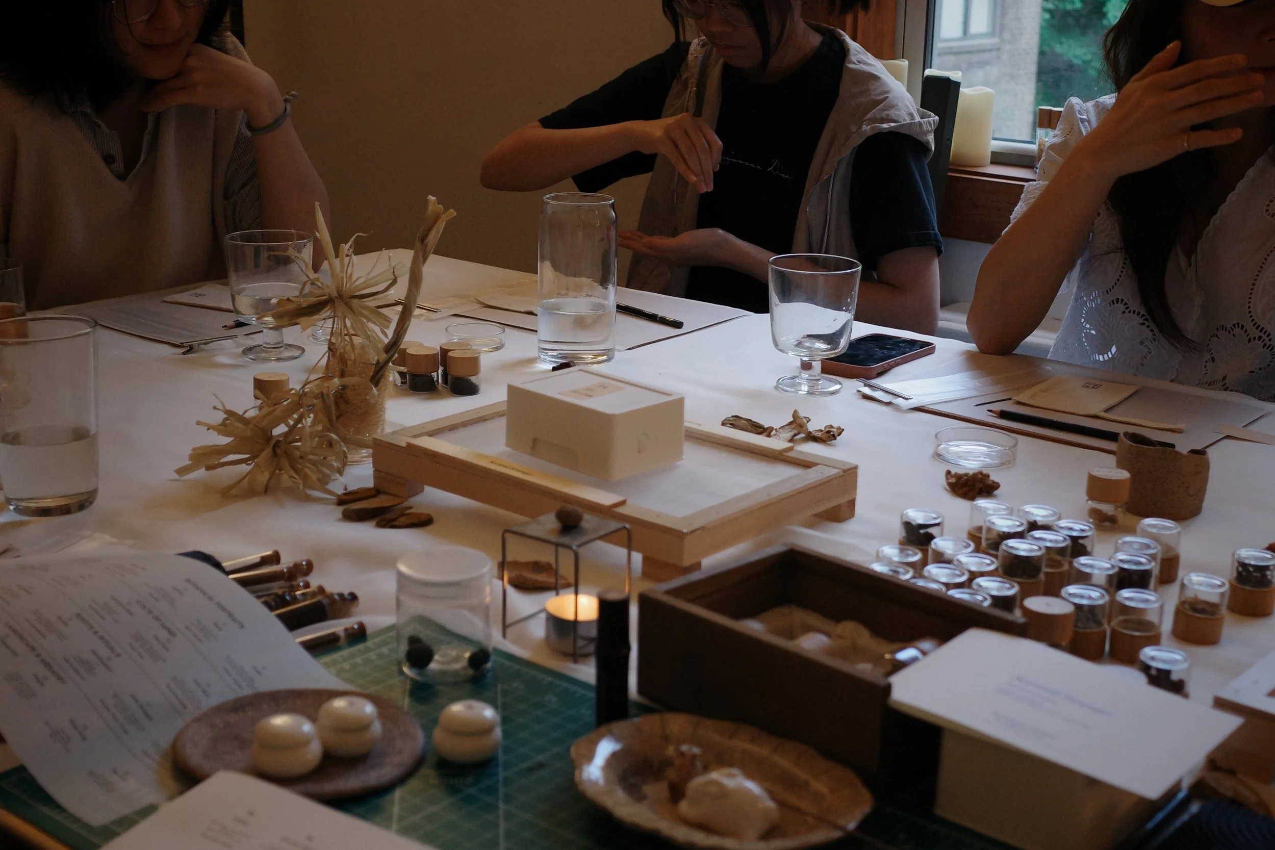 Guests gathering around an Oblique Table scent workshop in NYC, exploring Chinese herbs, incense materials, and sensory rituals together.