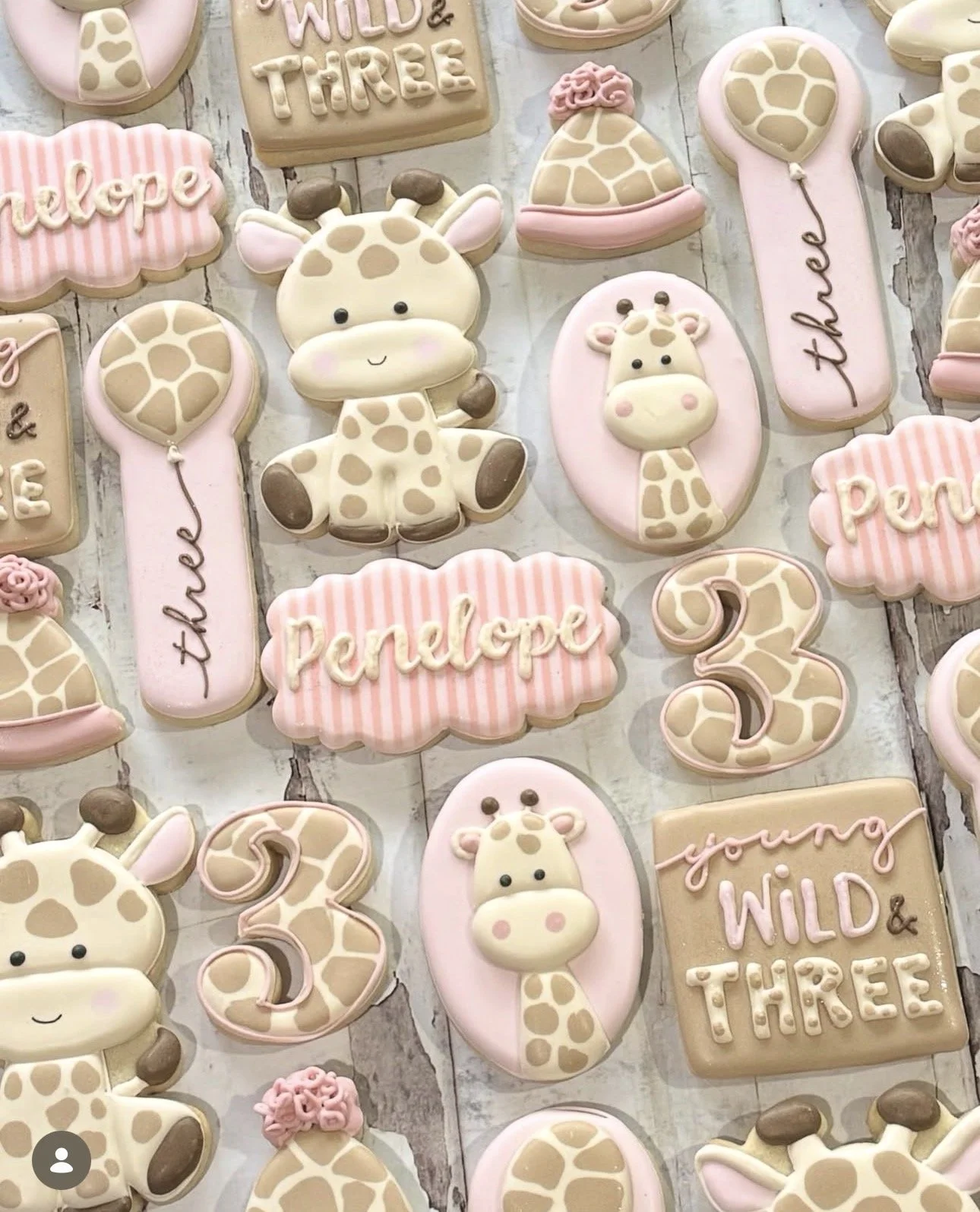 Pastel giraffe-themed cookies featuring baby giraffes, giraffe-print shapes, number threes, and welcome baby messages