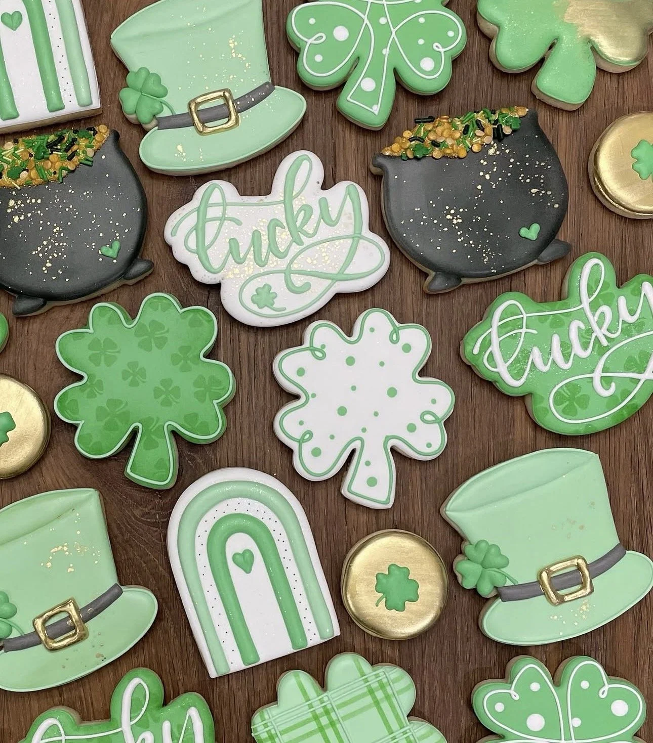 Assorted St. Patrick’s Day sugar cookies decorated as shamrocks, leprechaun hats, pots of gold, rainbows, and “Lucky” lettering