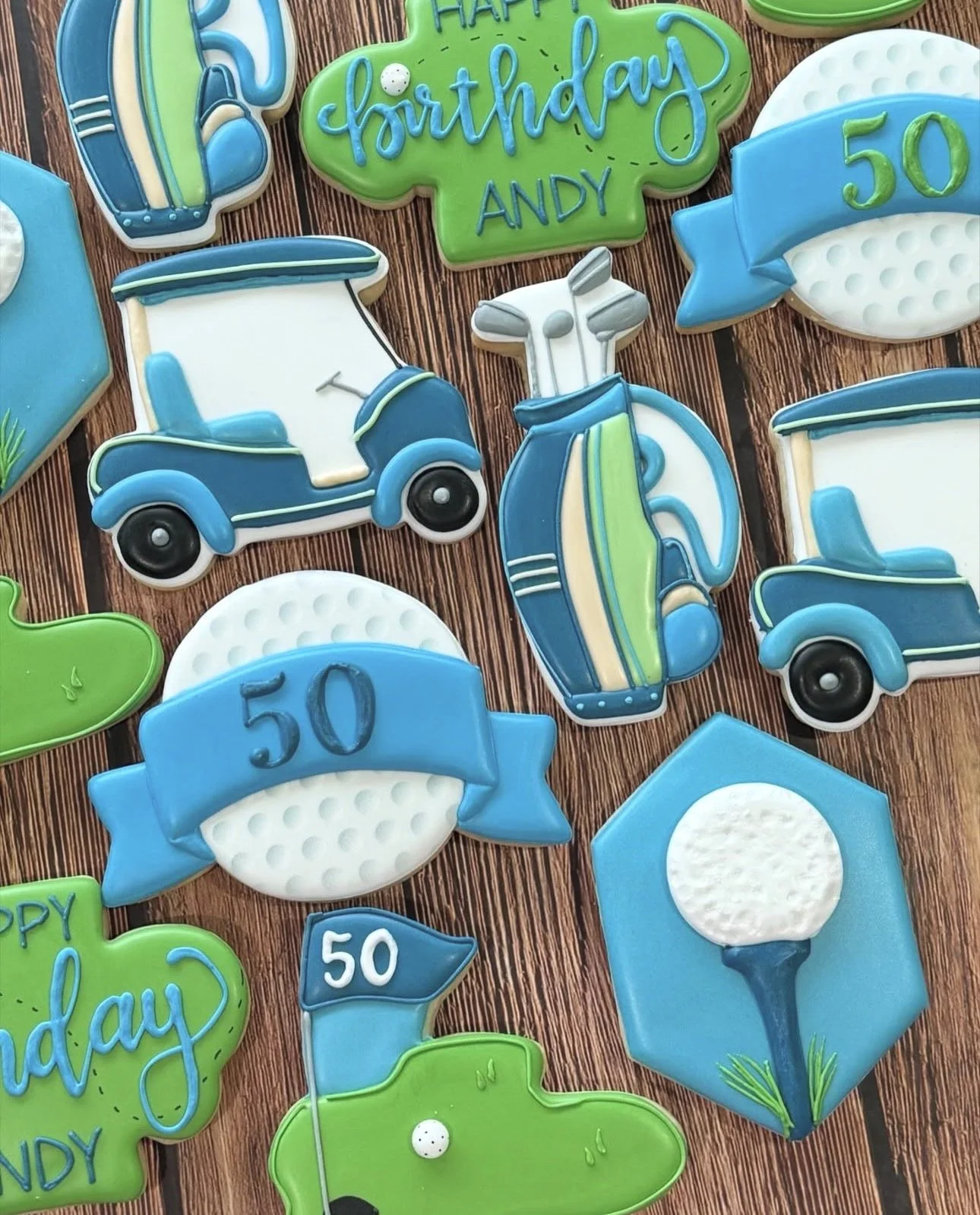 Golf-themed 50th birthday cookies featuring golf carts, clubs, balls, flags, and green birthday plaques