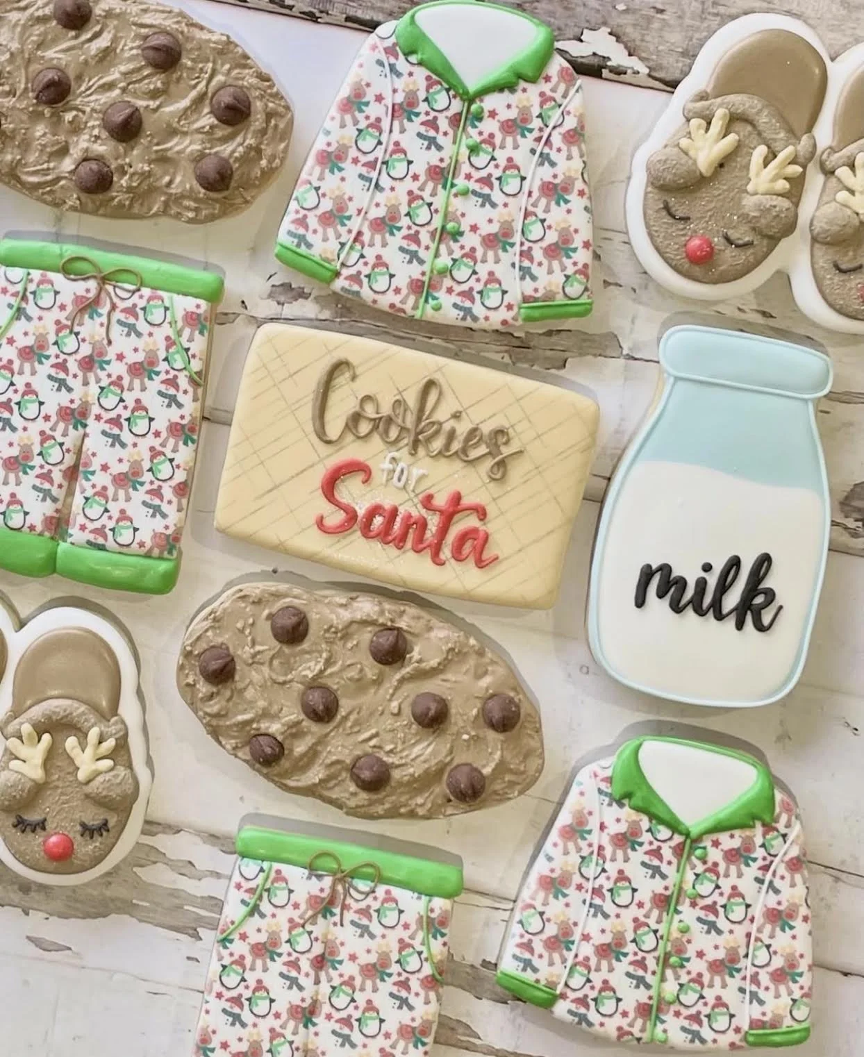 Assorted Christmas cookies, including reindeer, chocolate chip cookies, Santa pajamas, and a milk carton cookie reading “Cookies for Santa.”