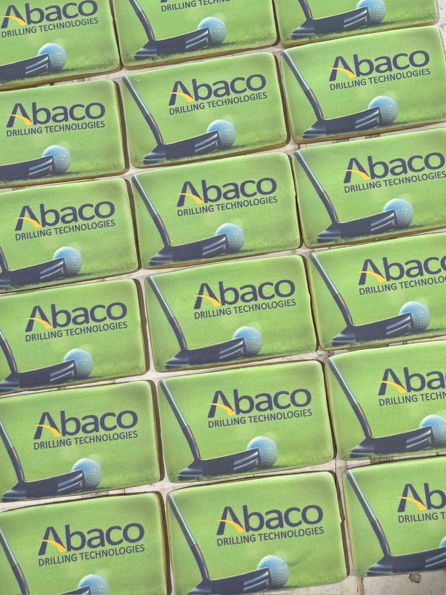 Pattern of green Abaco Drilling Technologies promotional cards featuring a drilling tool and ball graphic.