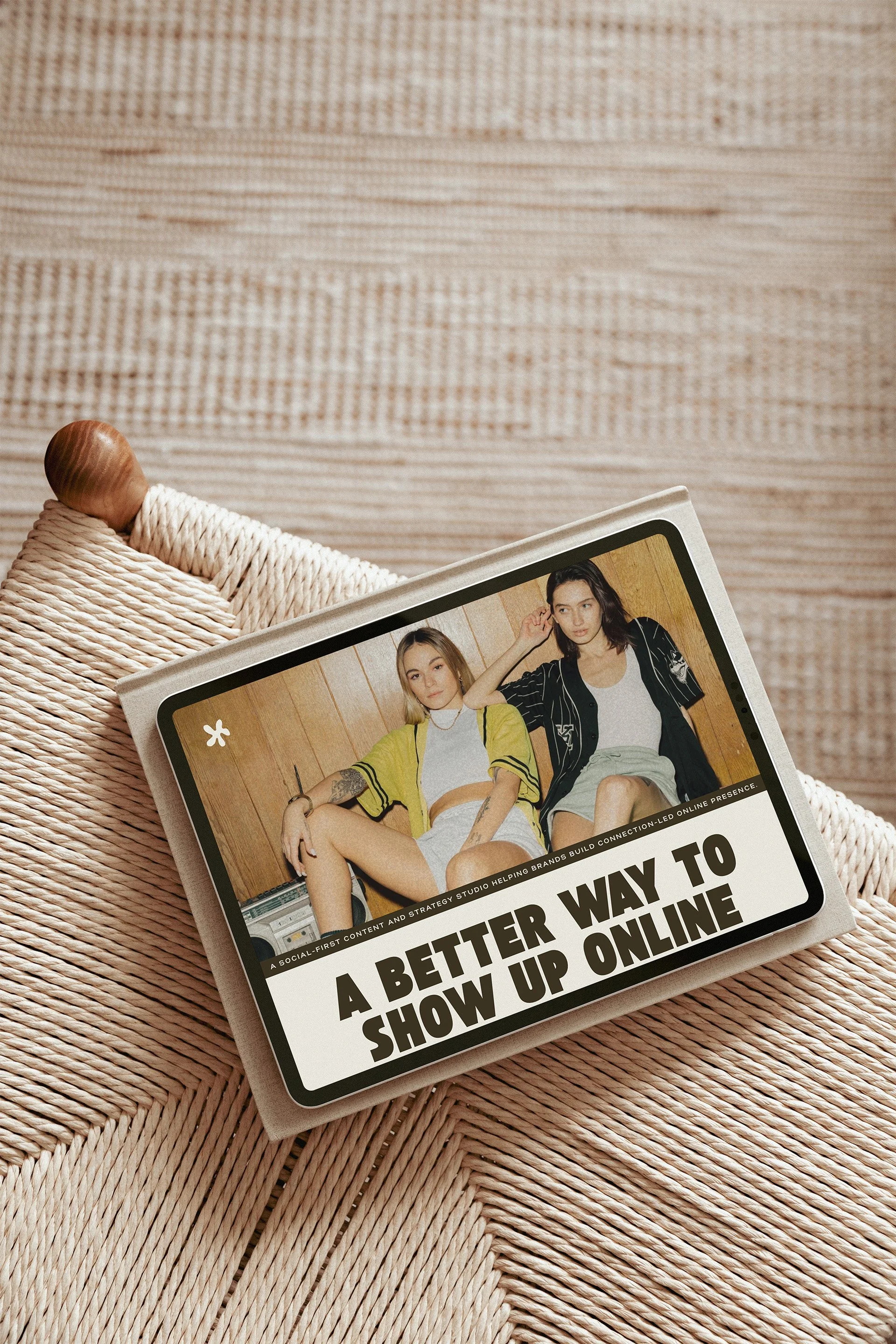 Magazines or books on a woven surface with a cover page featuring two young women sitting and posing, with headline text about improving online presence and social media strategy.