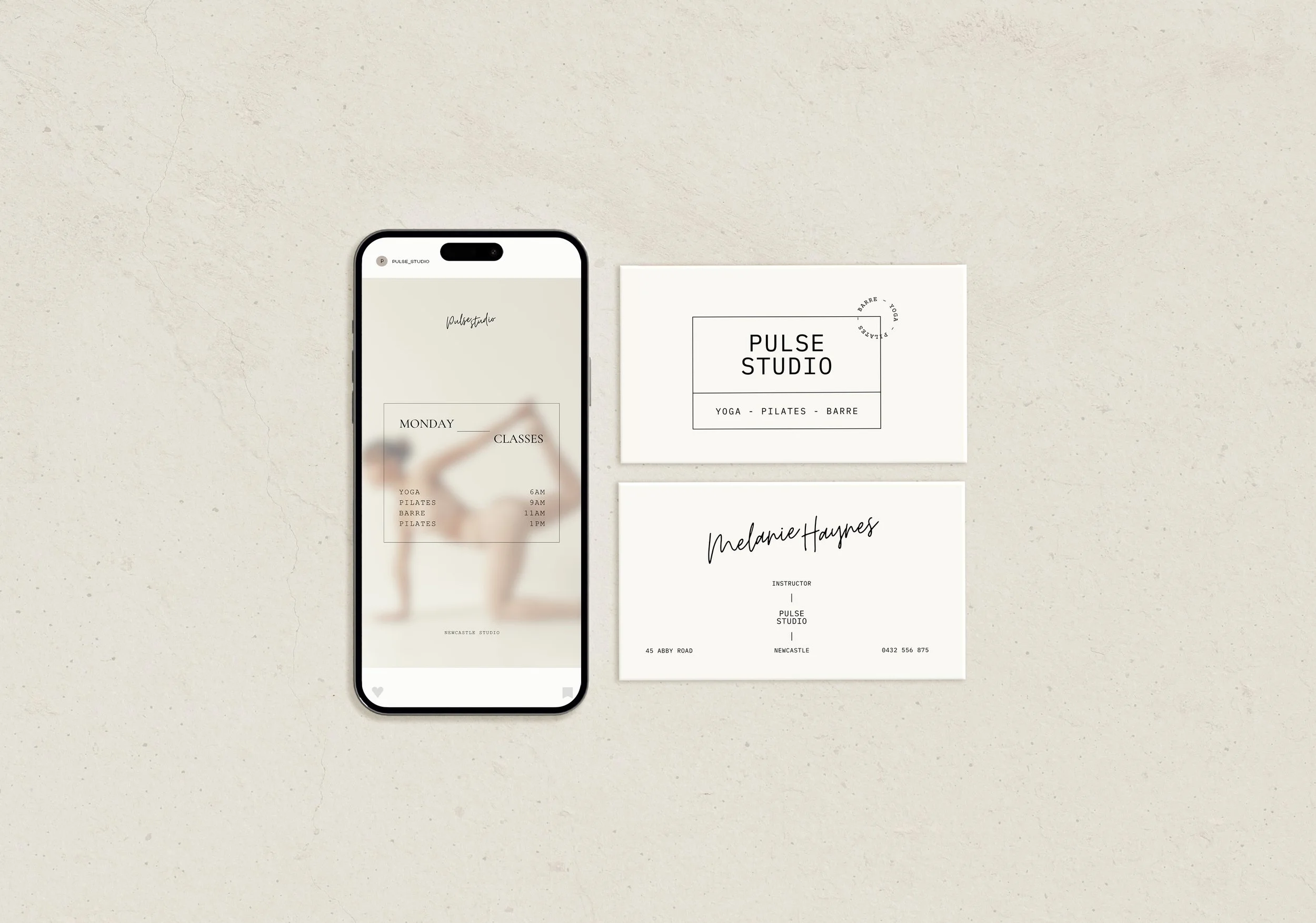 A flat lay image of a smartphone with a schedule of classes and a business card for Pulse Studio on a light textured surface.
