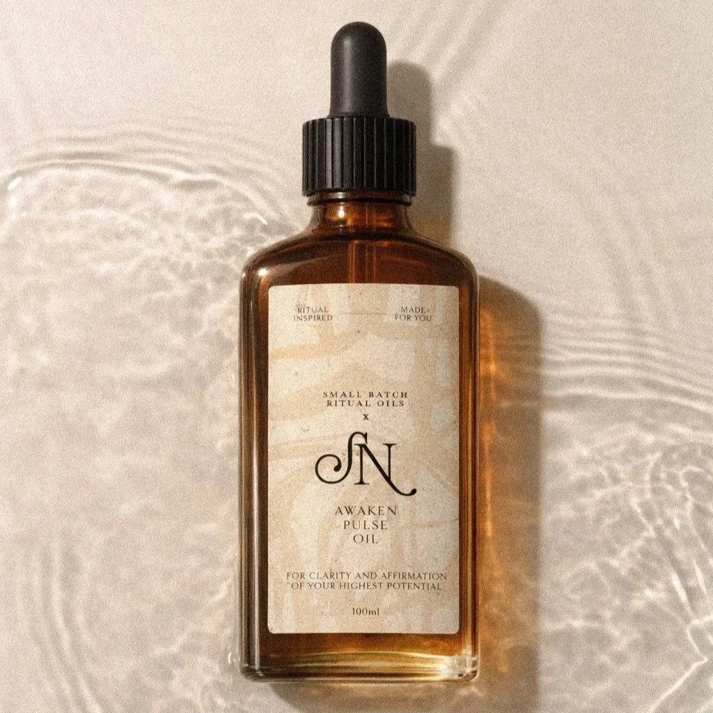 Amber glass dropper bottle labeled 'Awaken Pulse Oil' with text indicating it is for clarity and affirmation of highest potential, 100ml.