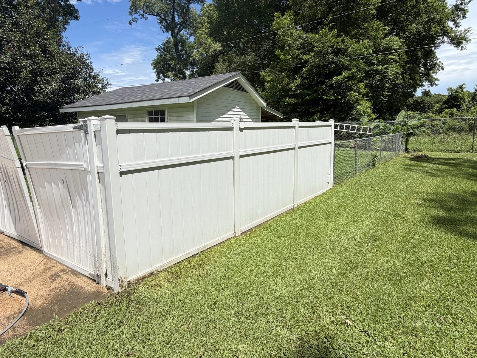 White vinyl fence after professional exterior cleaning