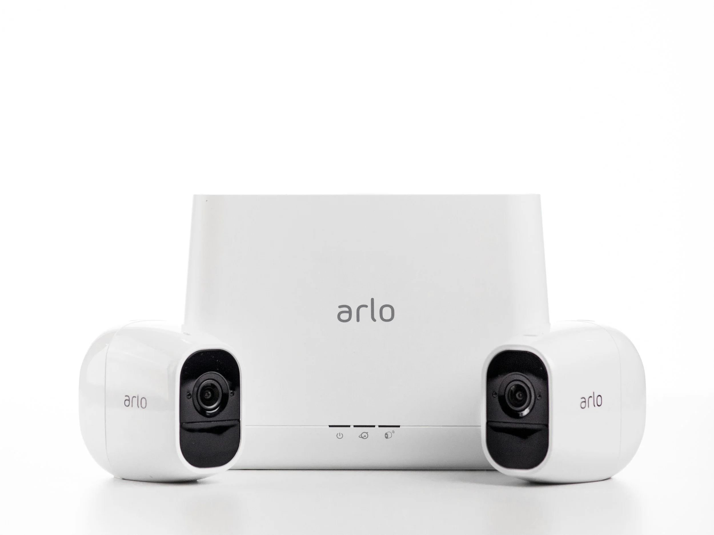 Close-up of a white Arlo security camera system with multiple cameras and the Arlo logo visible.