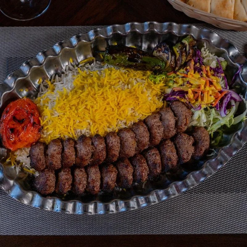 Persian kabab platter with grilled beef kababs, saffron rice, grilled tomato, peppers, and salad at Shiraz Persian Cuisine.