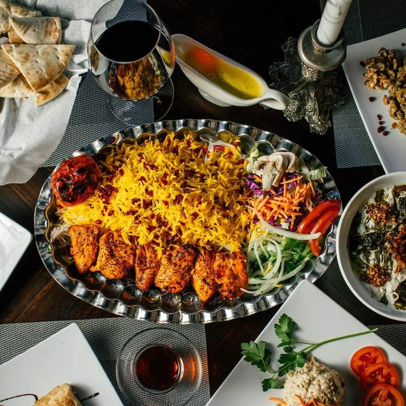Persian grilled chicken with saffron rice, tomato, salad, and traditional sides at Shiraz Persian Cuisine.