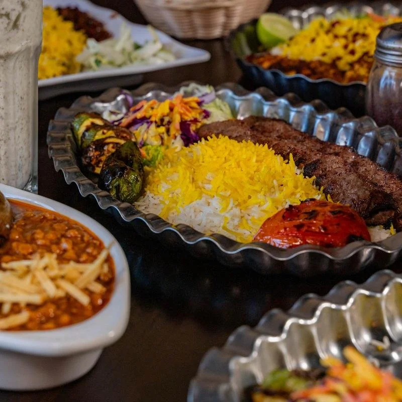 Persian meal with kababs, saffron rice, grilled vegetables, salad, and traditional sides at Shiraz Persian Cuisine.