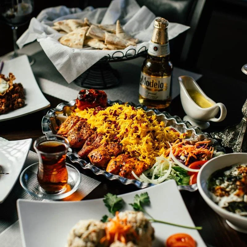 Persian grilled chicken with saffron rice, vegetables, flatbread, and traditional sides at Shiraz Persian Cuisine.
