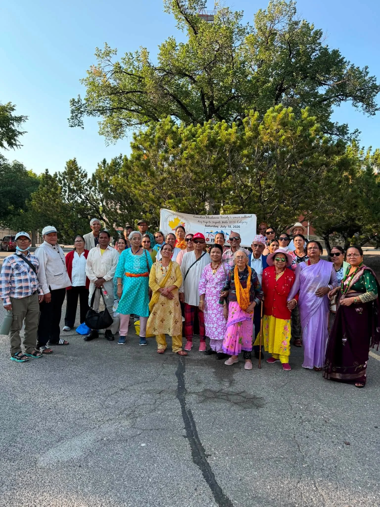 Group of CBS seniors in traditional clothing standing together on a day trip to Nepali Mela in Calgary