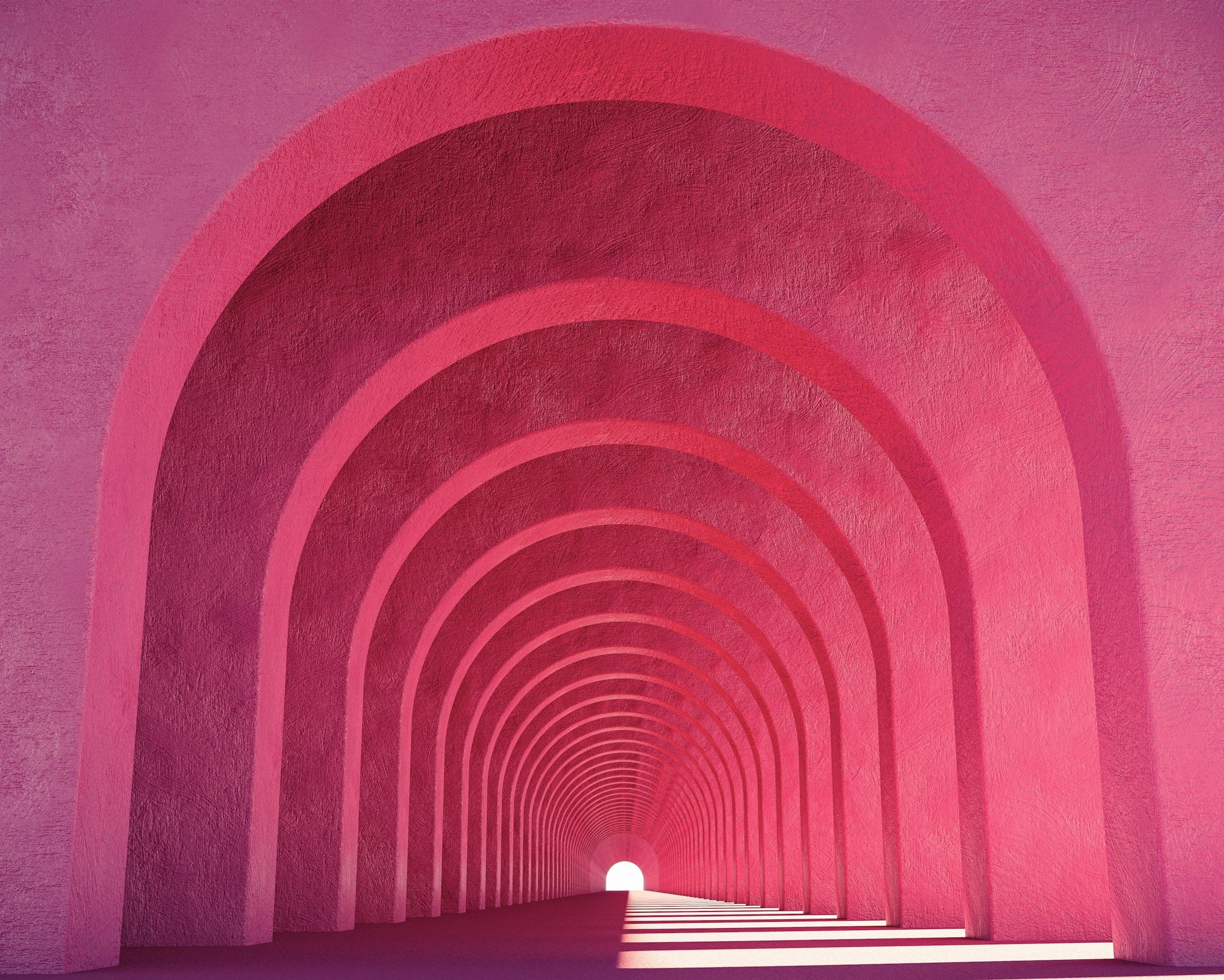 A pinkish-red tunnel with concentric arches leading to an end with a bright white circle. The tunnel has textured walls and steps leading outward from the circle.