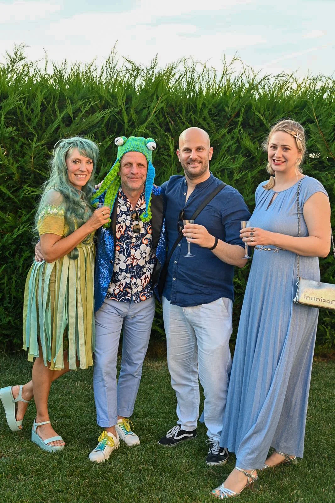 Members and guests wearing fun costumes and holding drinks at the Year-End Summer Party.