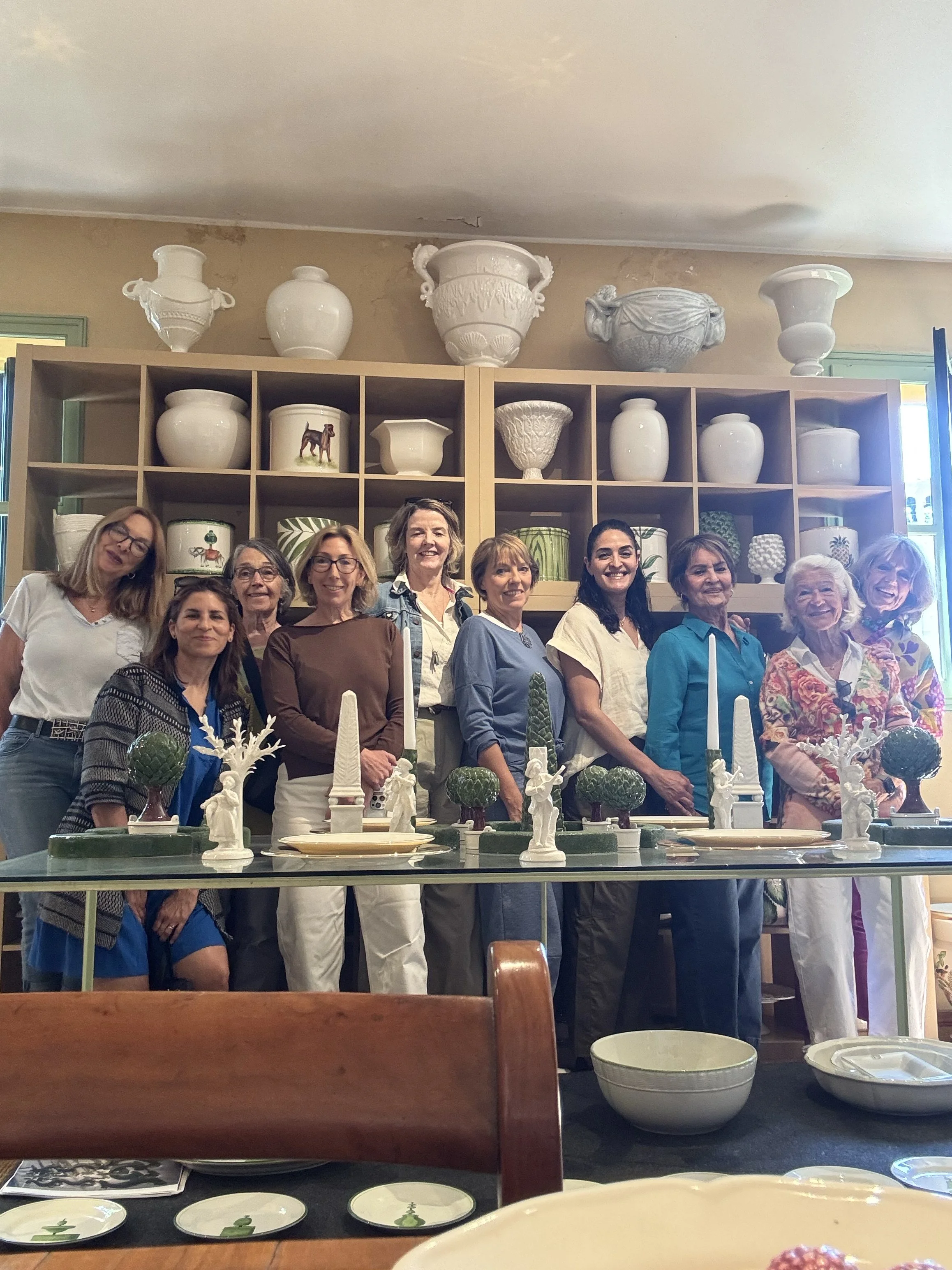 Group of members posing behind a decorative table in a craft studio.