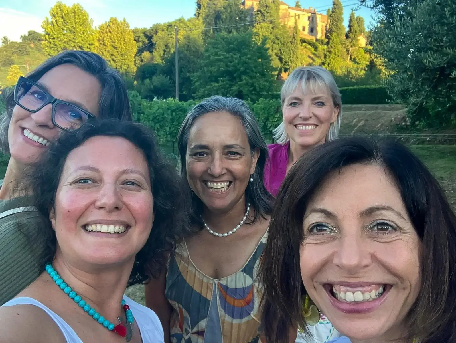 Group of international friends smiling together outdoors in the Euganean Hills near Padova.