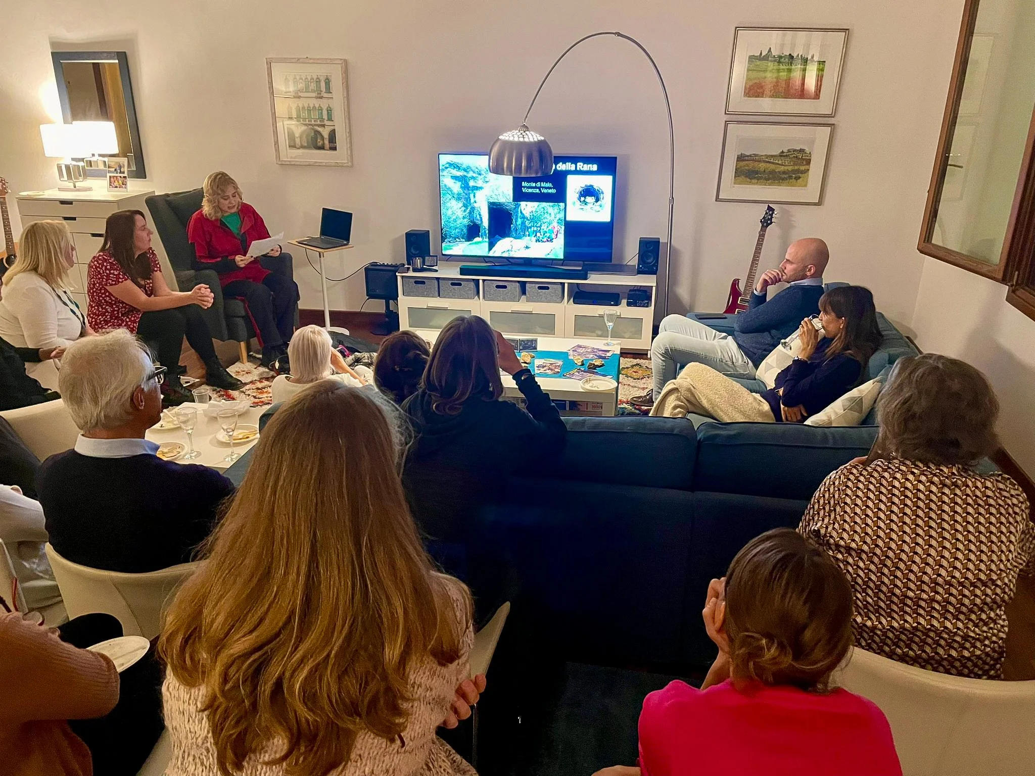 Group members sitting in a living room watching a presentation for the geography club.