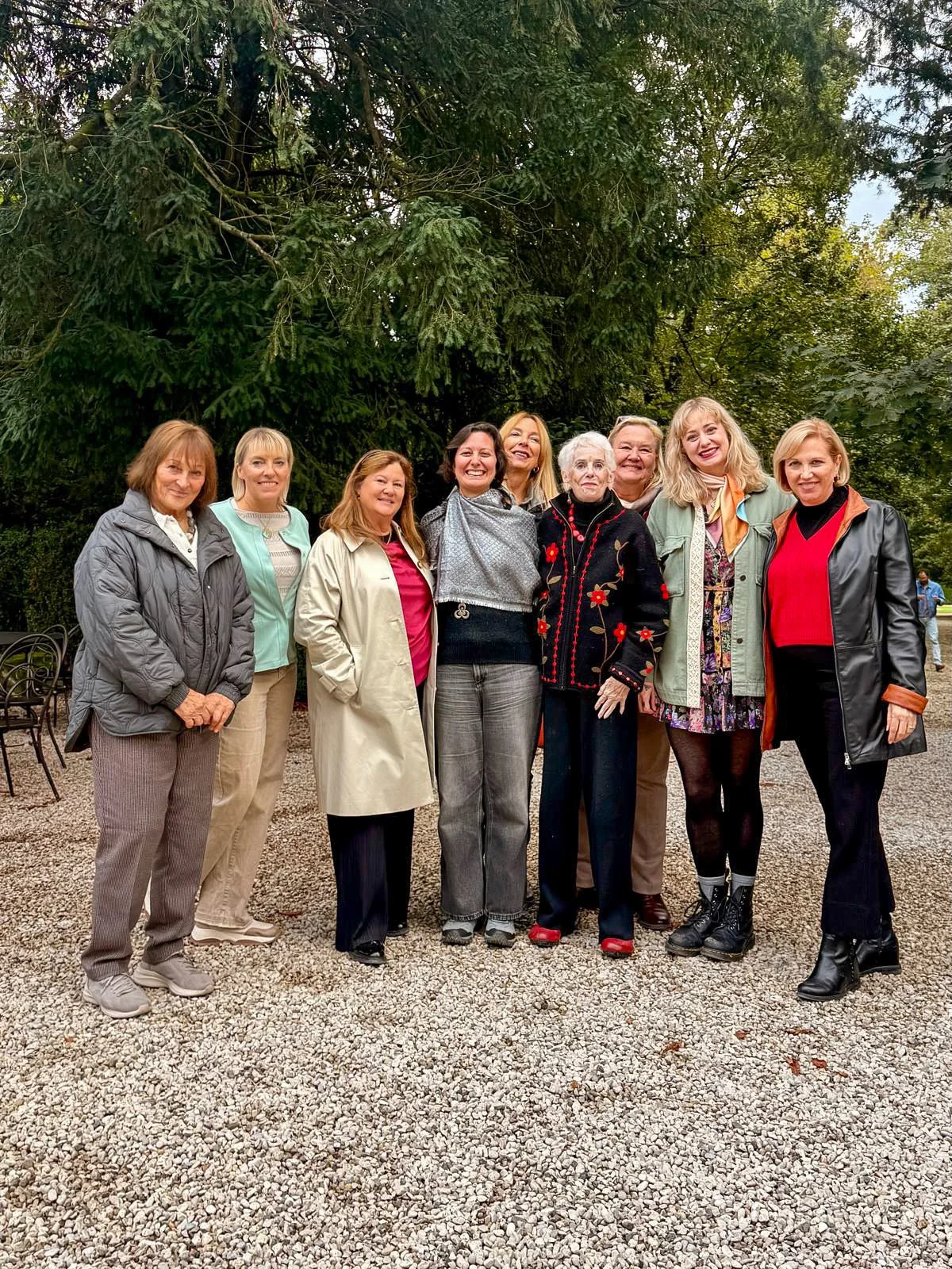 Group of members standing together on a gravel path outdoors.