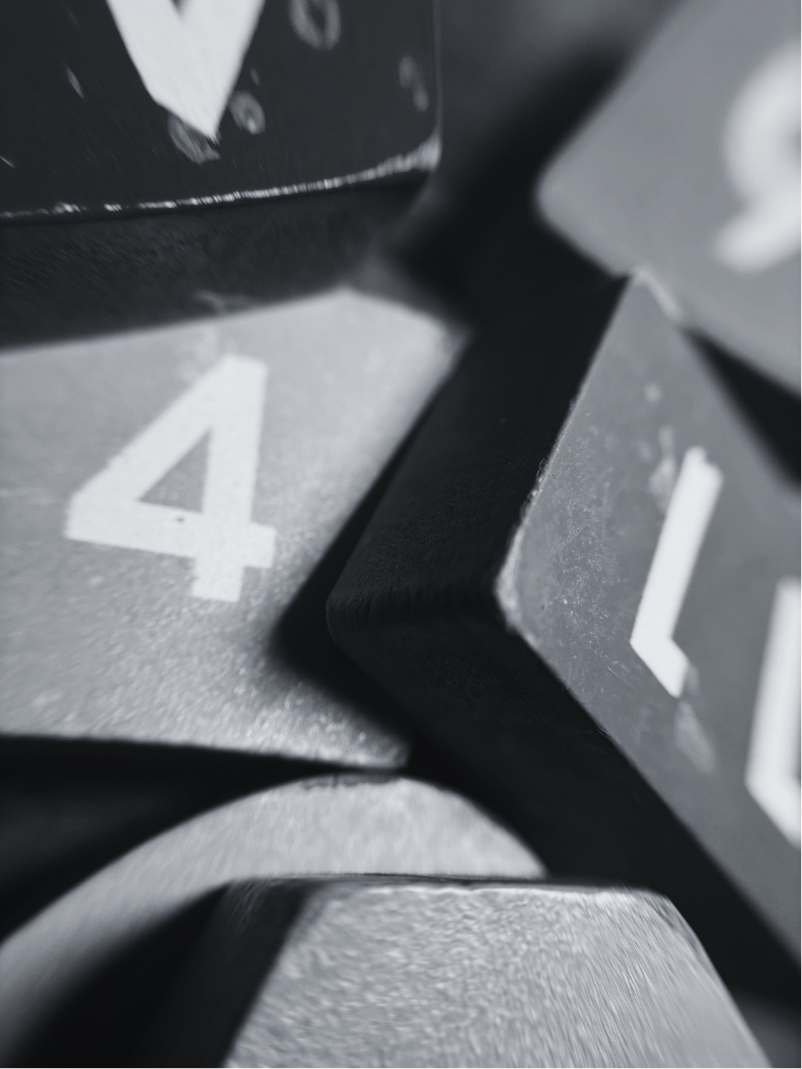 Close-up view of a black plastic or metal object with a number 4 printed in white on a gray background.