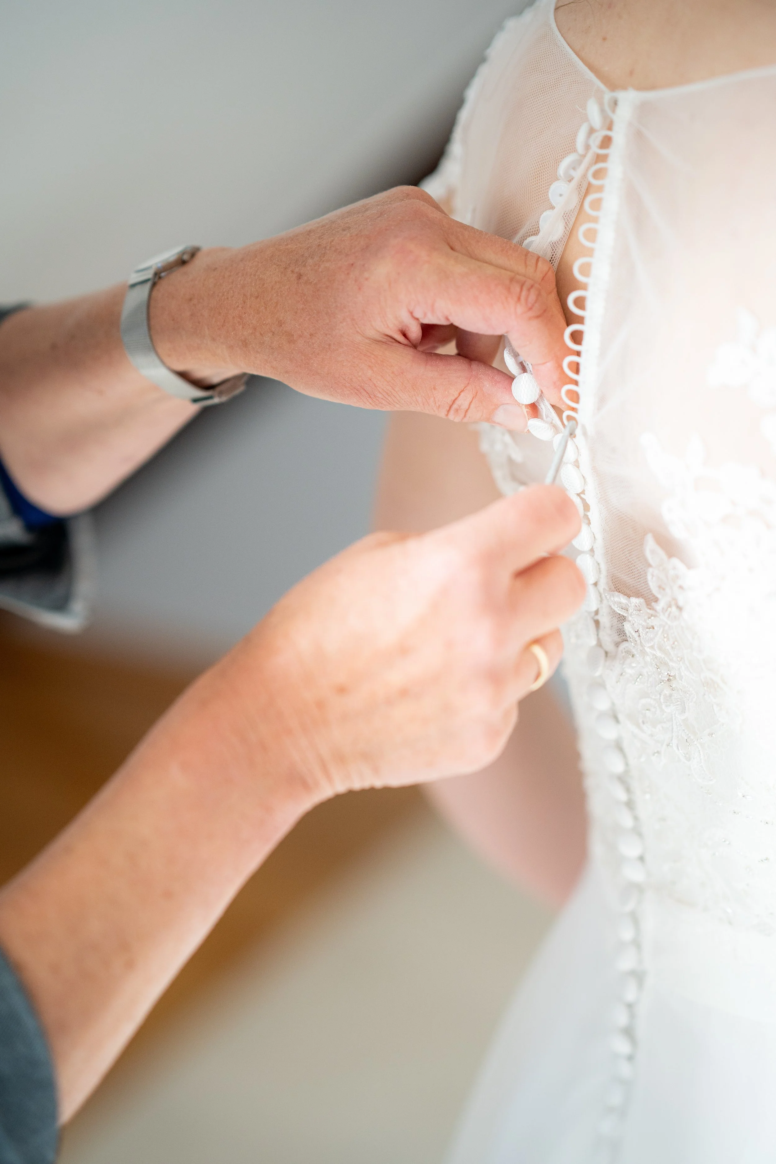close-up-shot-person-helping-zip-beautiful-wedding-dress.jpg
