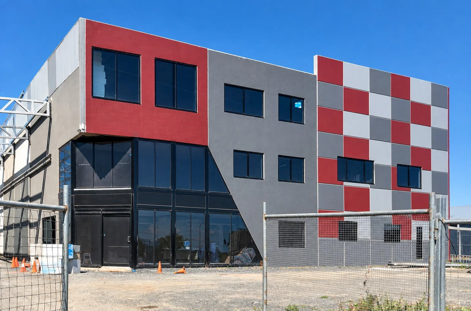 QLD Sheds office under construction with red and grey exterior panels
