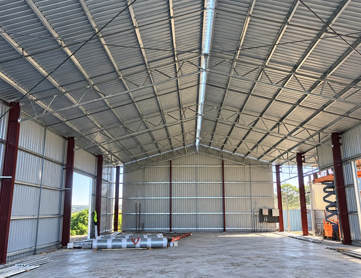 Open-plan shed interior showing steel roof framing and a clear span