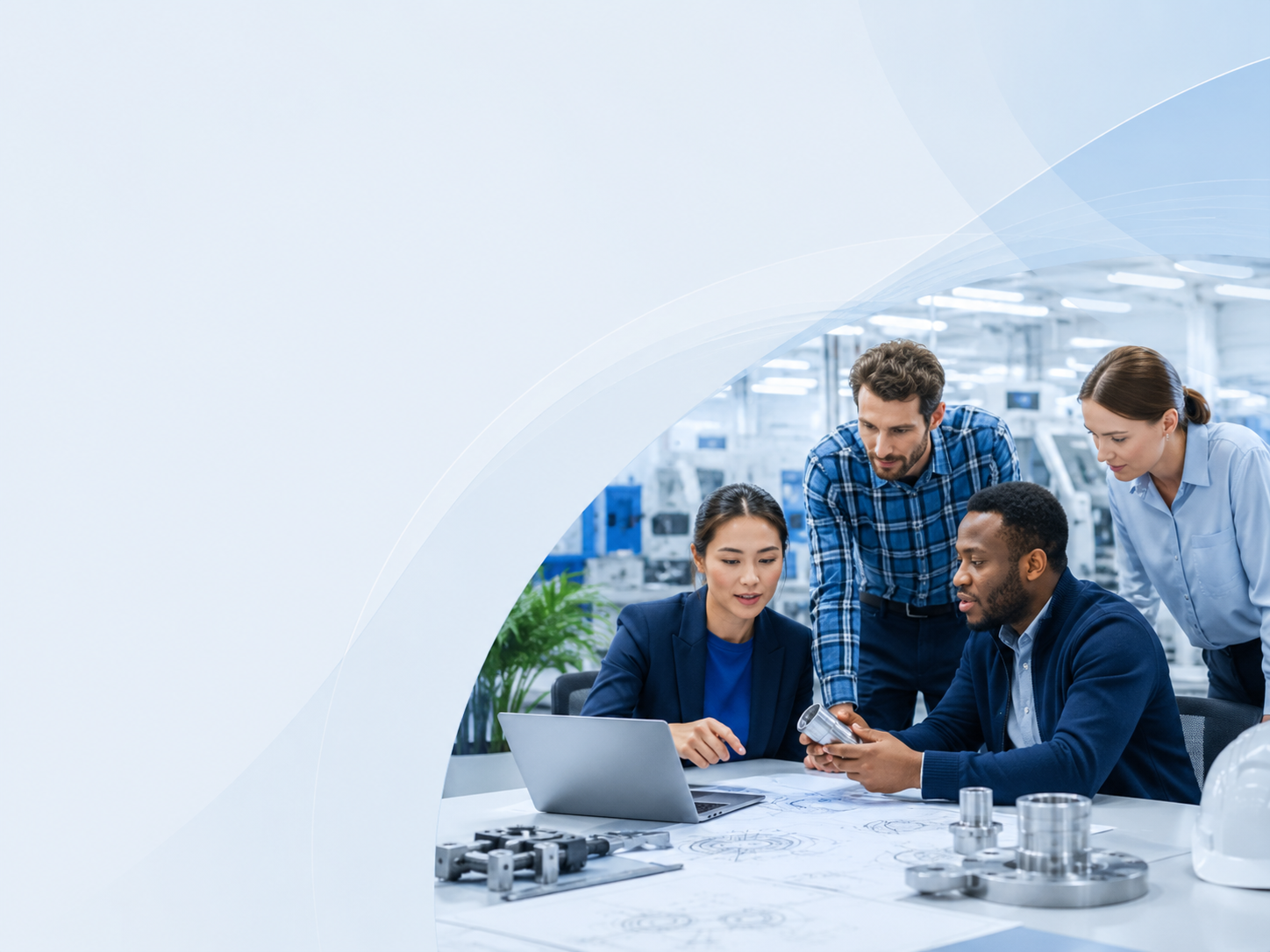Group of engineers and a designer discussing a project in an industrial laboratory, with metallic components on the table and blueprints.