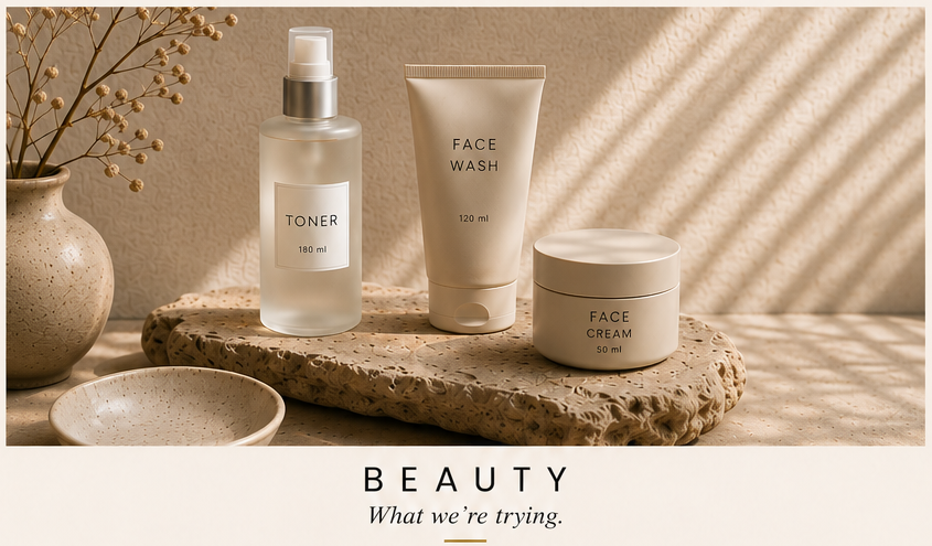 Skincare products including toner, face wash, and face cream on a textured surface with neutral tones and natural lighting.