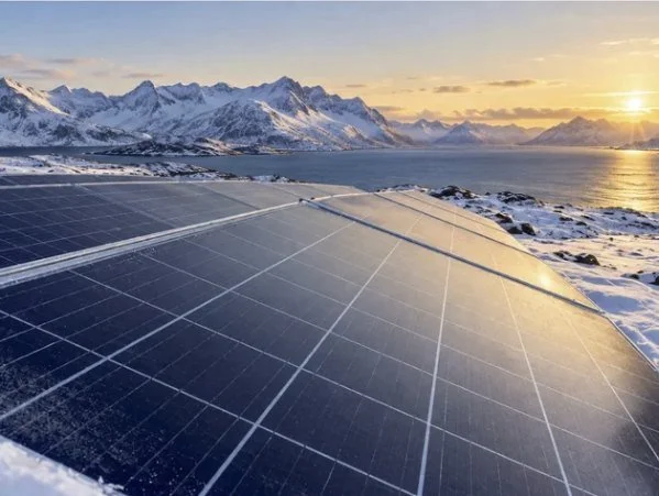 Bifacial solar panels in a snowy Arctic landscape, capturing direct and snow-reflected sunlight