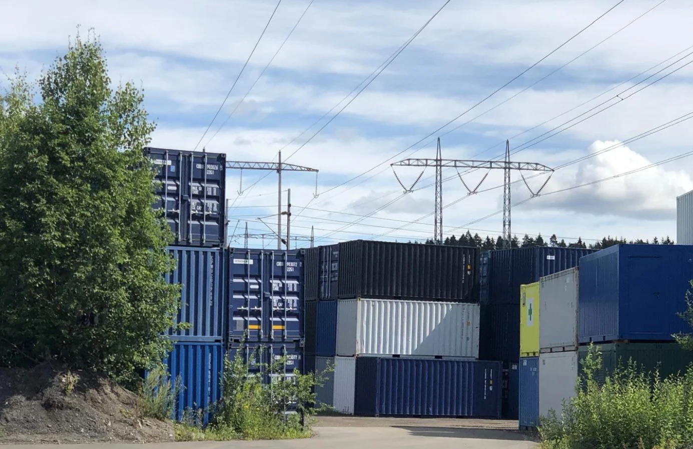 Shipping container yard in Norway with power lines in the background