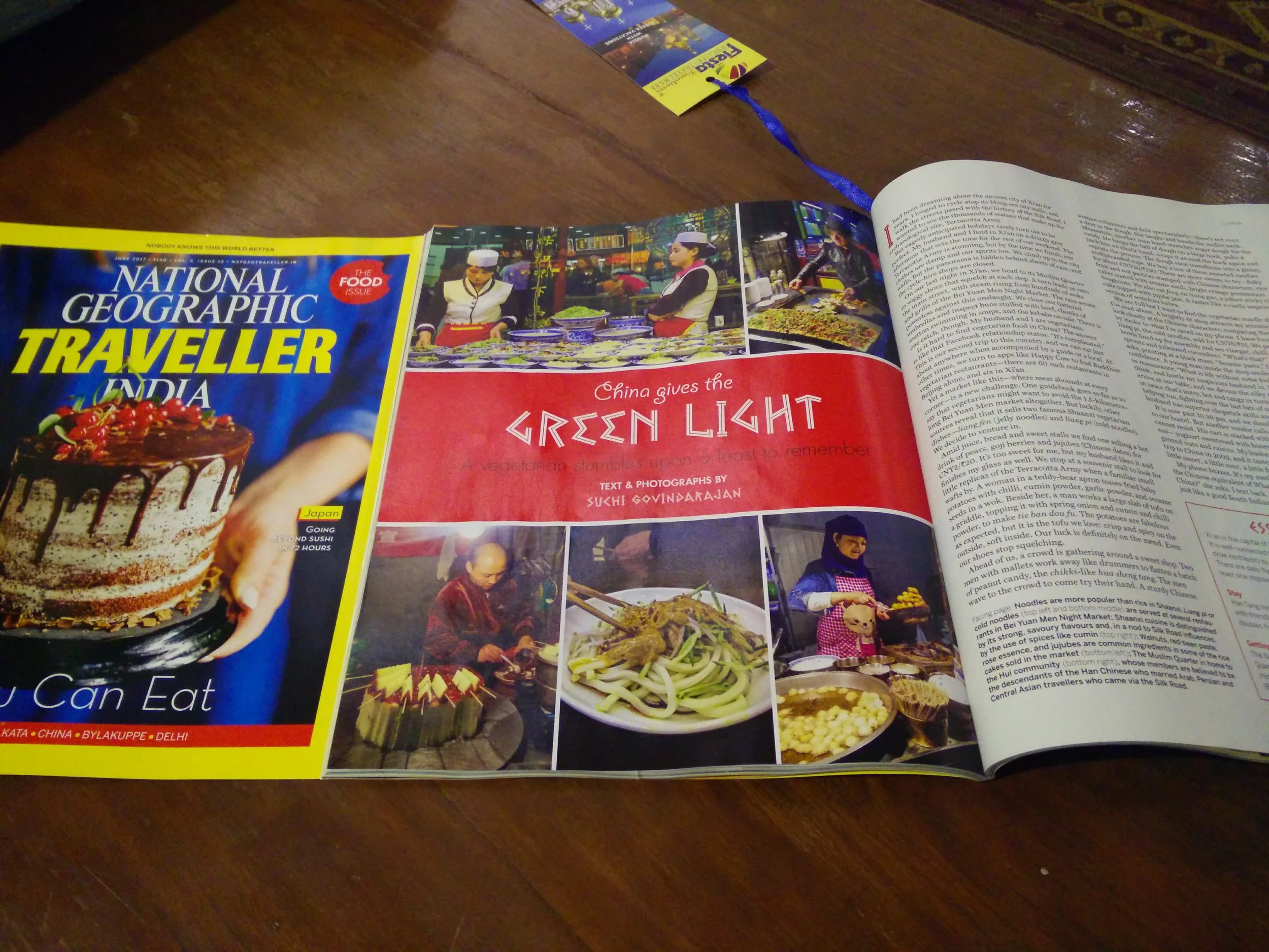 Open magazine page featuring travel and food from India and China, with images of restaurants, dishes, and chefs preparing food.