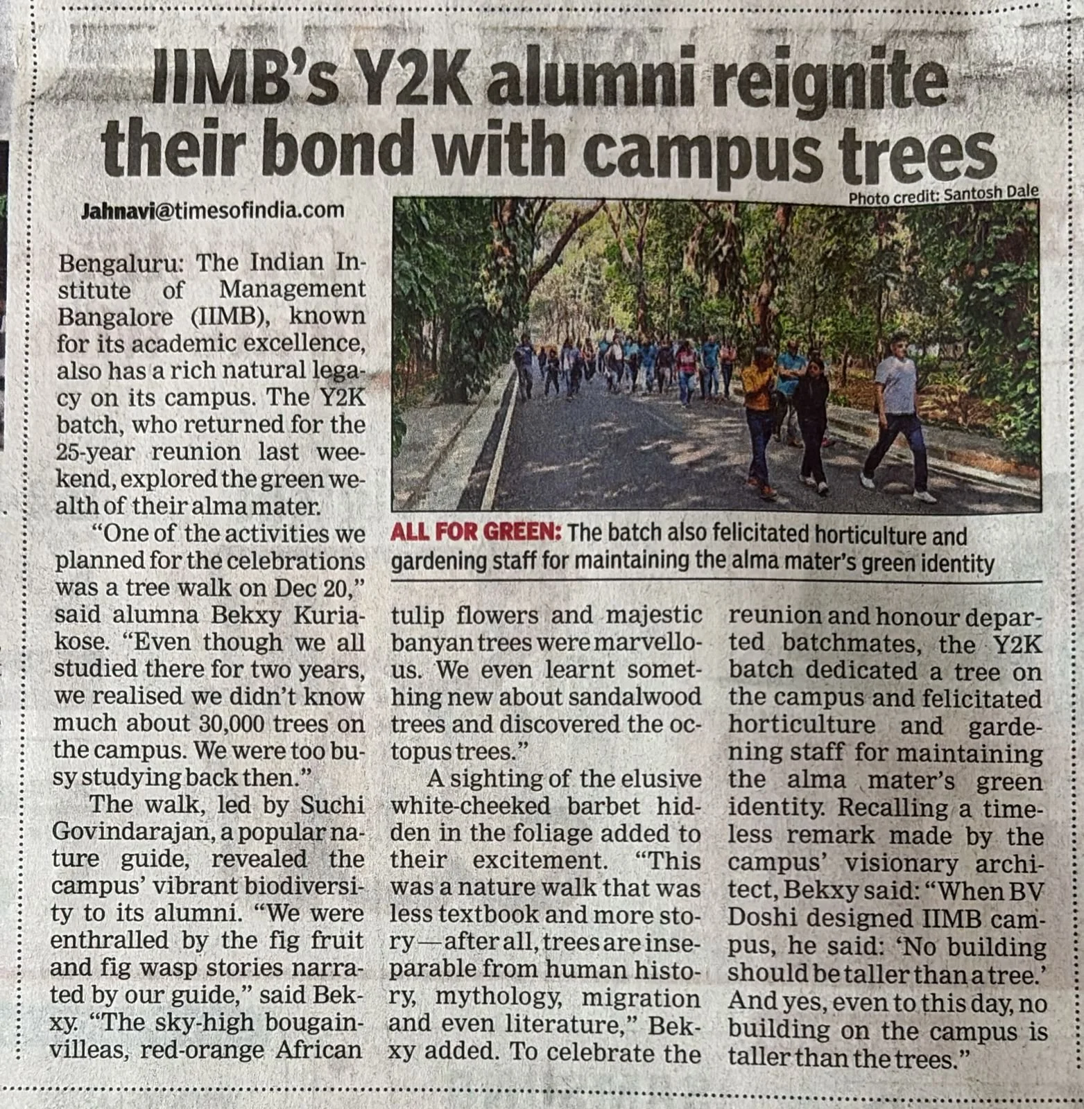 A newspaper article with the headline "IIMB's Y2K alumni reignite their bond with campus trees." The article includes a photo of a group of people walking on a road surrounded by green trees. The text discusses alumni activities related to planting and maintaining campus trees.