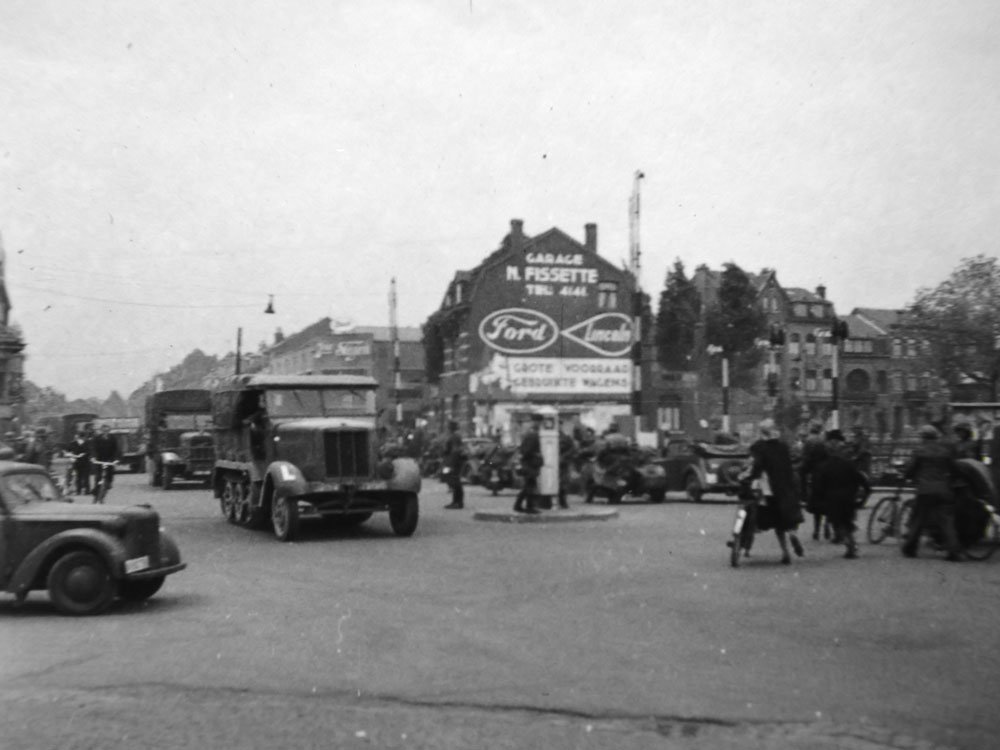 Durchfahrt durch eine Kreuzung im Westen – im Hintergrund die Garage M. Fissette mit Ford-Lincoln-Werbung.