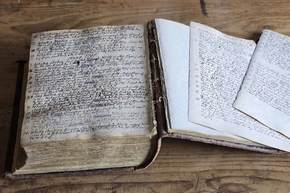 Aufgeschlagenes historisches Kirchenbuch mit handschriftlichen Einträgen aus dem 18. Jahrhundert bei der Restaurierung und Buchsanierung
