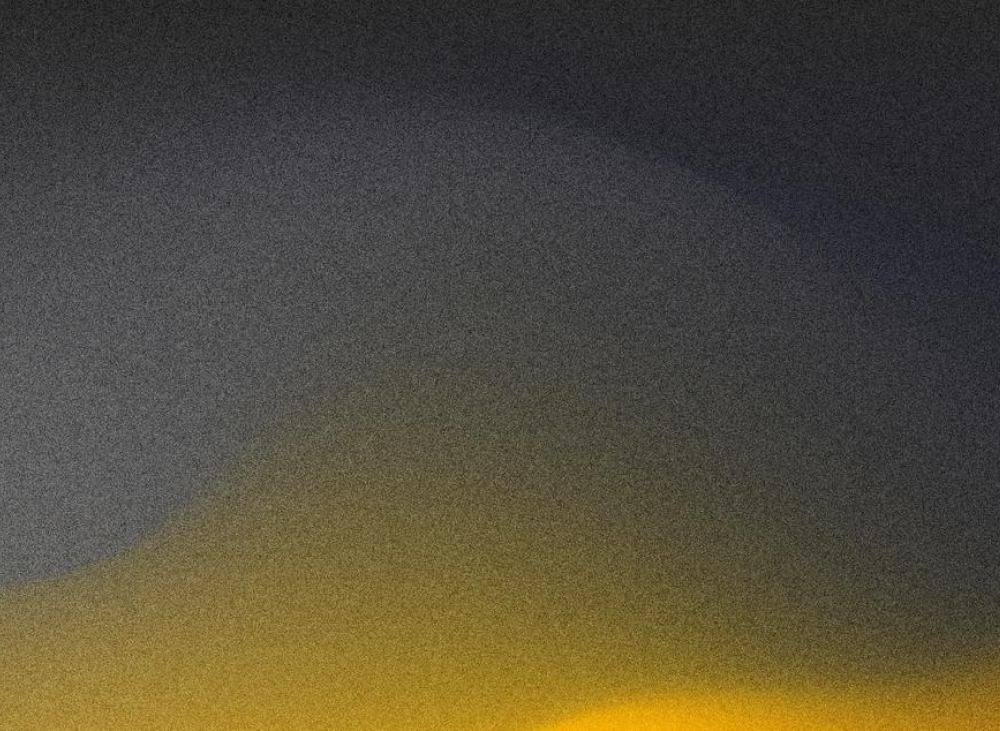 A gradient sky transitioning from dark navy at the top to bright yellow near the horizon.