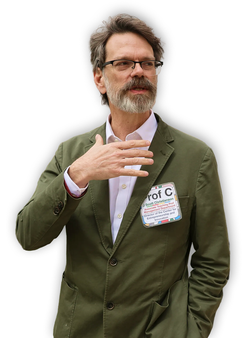 Prof C standing against a dark background.