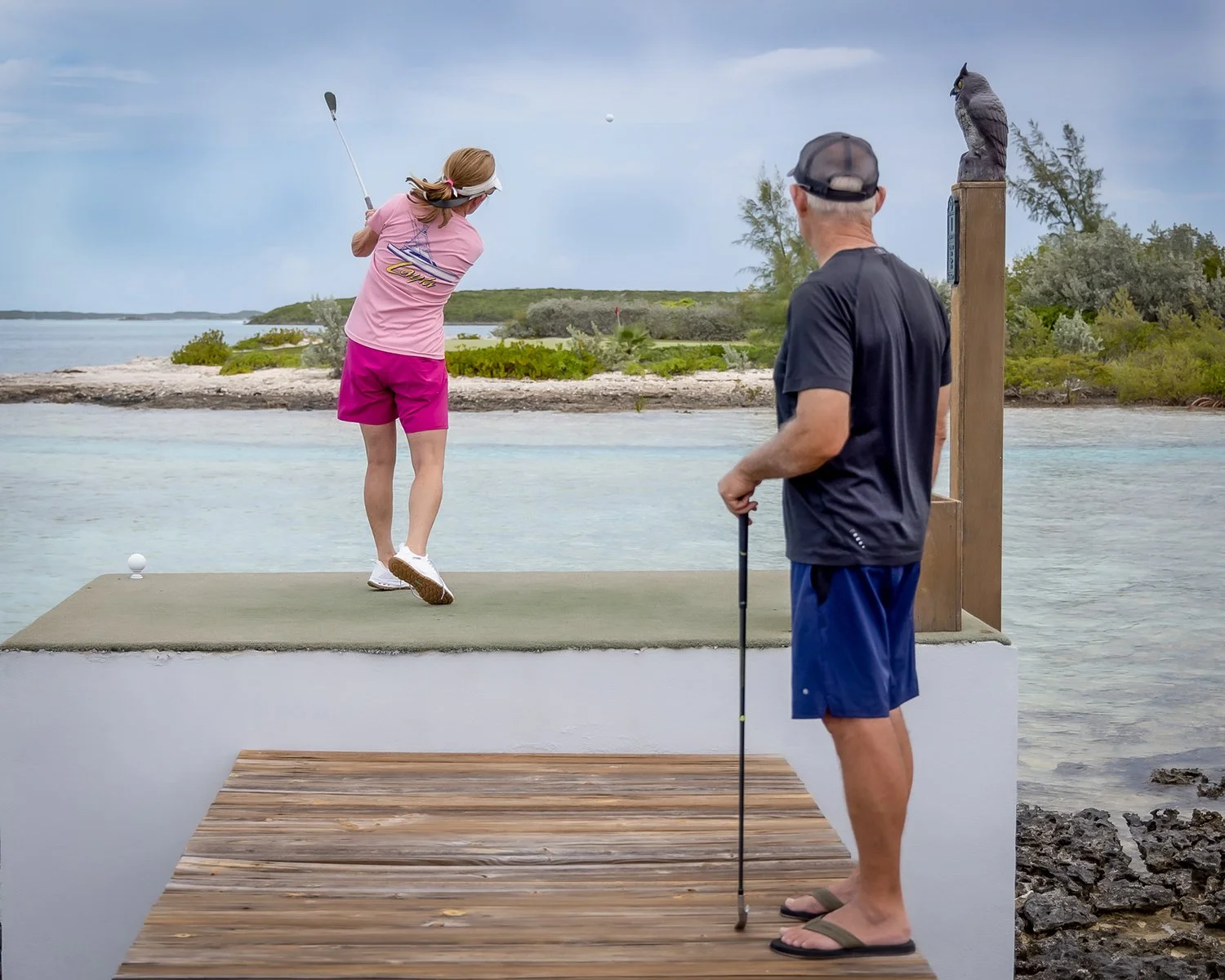 Luxury Travel and Active Lifestyle Photography of a Couple Playing Golf on a Coastal Water Hazard Tee Box