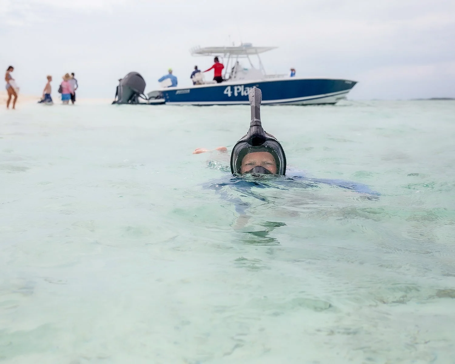 A Boy Wearing a Full-Face Snorkel Mask Swimming in Clear Ocean Water Capturing Marine Recreation Amenities and Snorkeling Excursions at a Luxury Island Resort