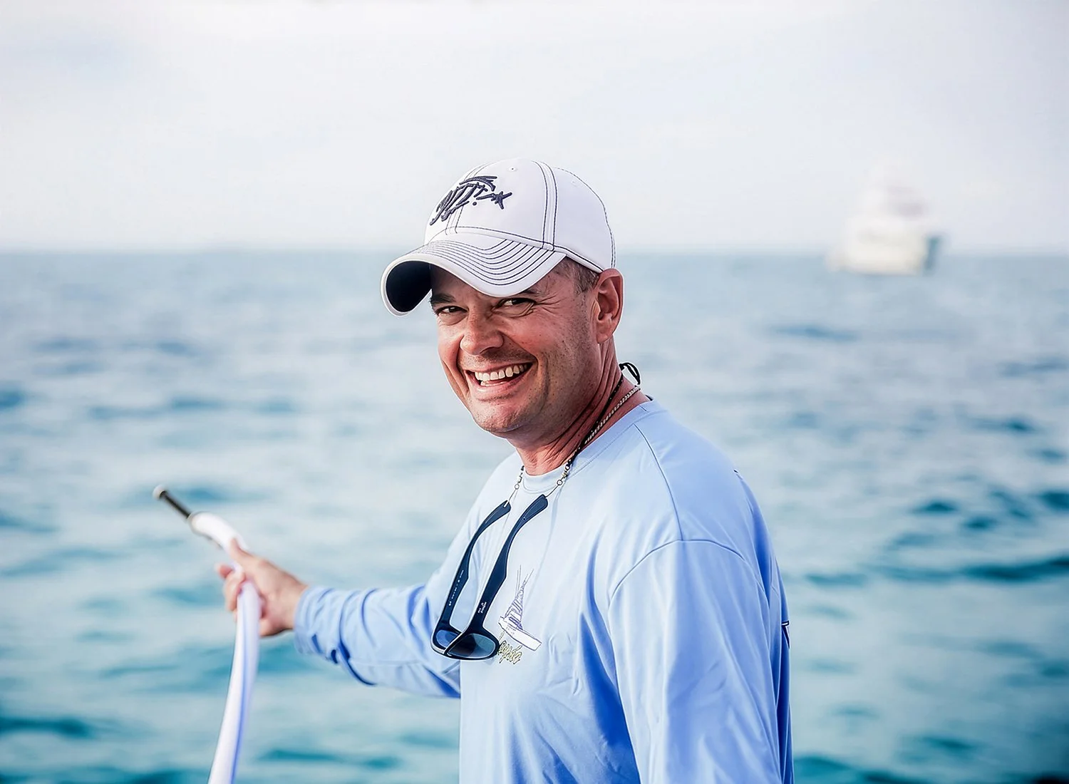 On-Location Lifestyle Portrait of a Smiling Boater with a Yacht Blurred in the Background