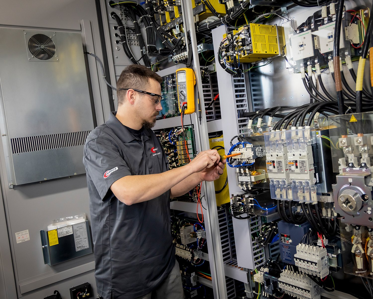Electrician Working on Electrical Panel in Manufacturing Facility