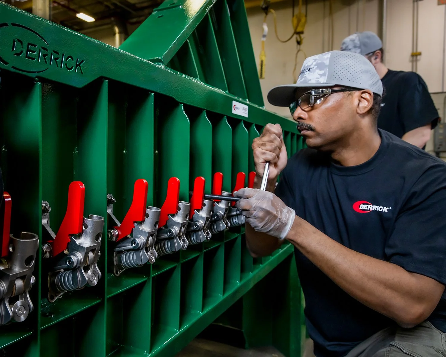 African American Male Wearing Protective Glasses and Tightening Bolts on Industrial Machinery