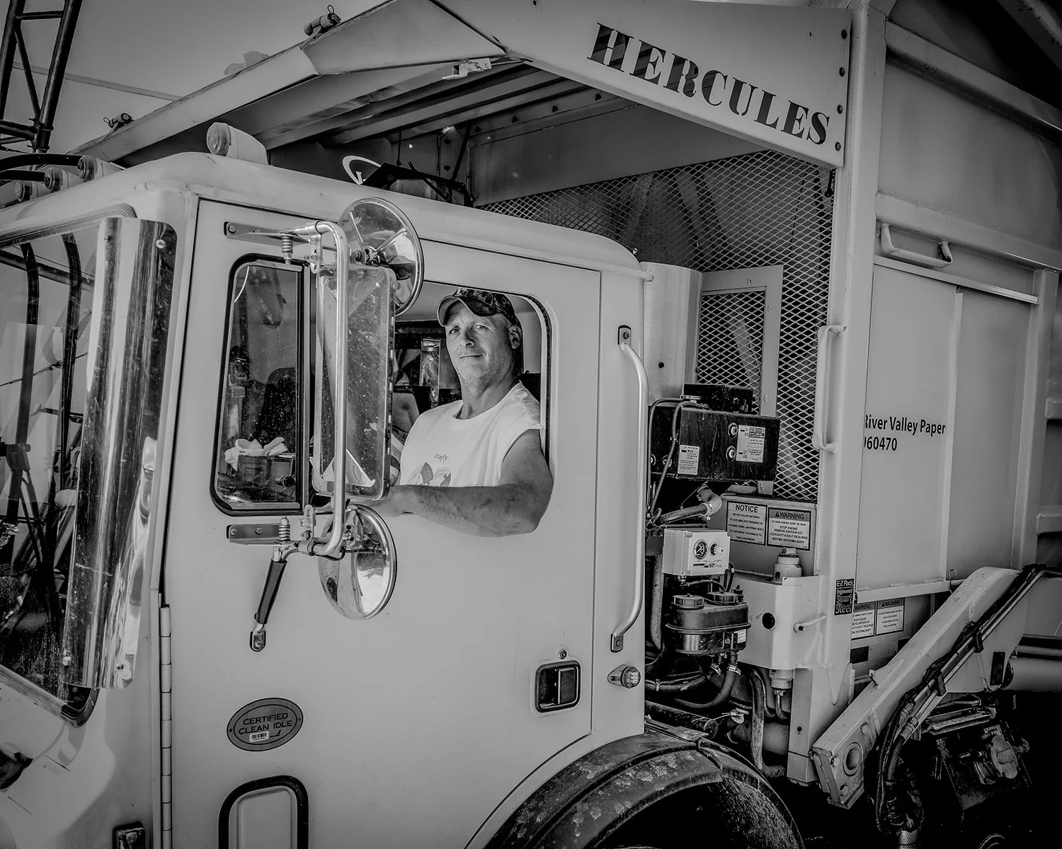 Black and White Portrait of Worker in Front Seat of Garbage Truck