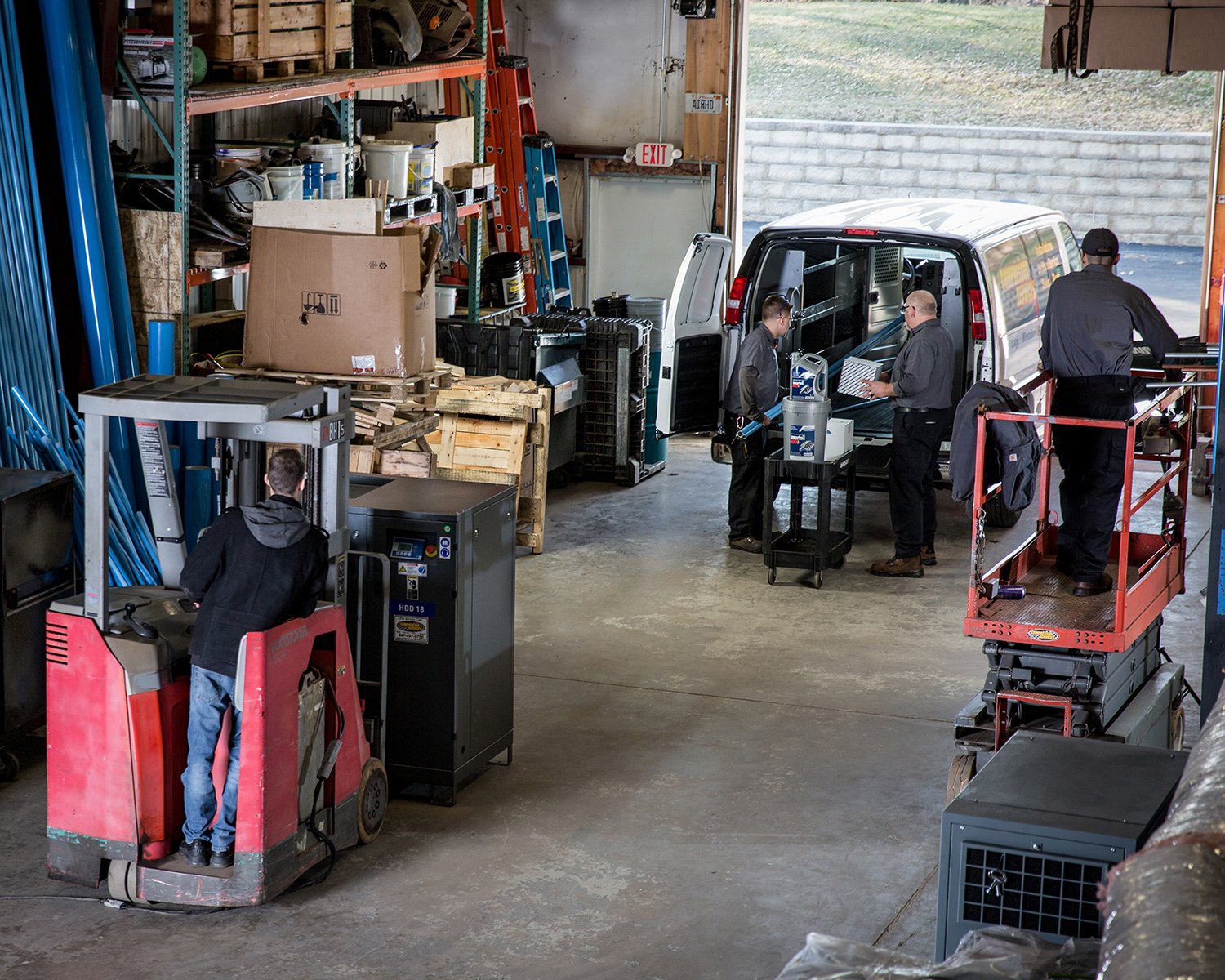Men Loading Heavy Equipment into Van in Warehouse