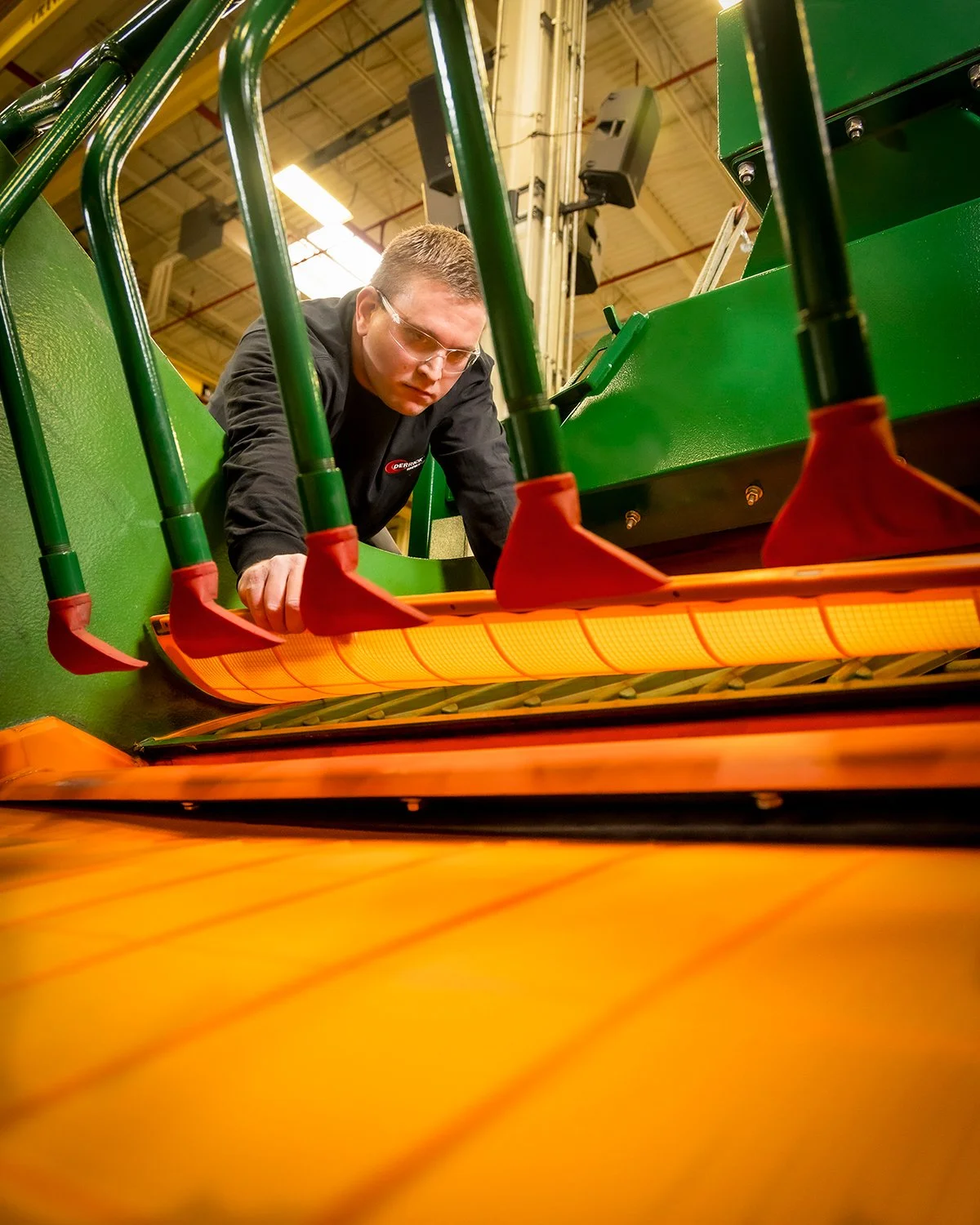 Low Angle Shot of Man Installing Screen on Large Industrial Machine
