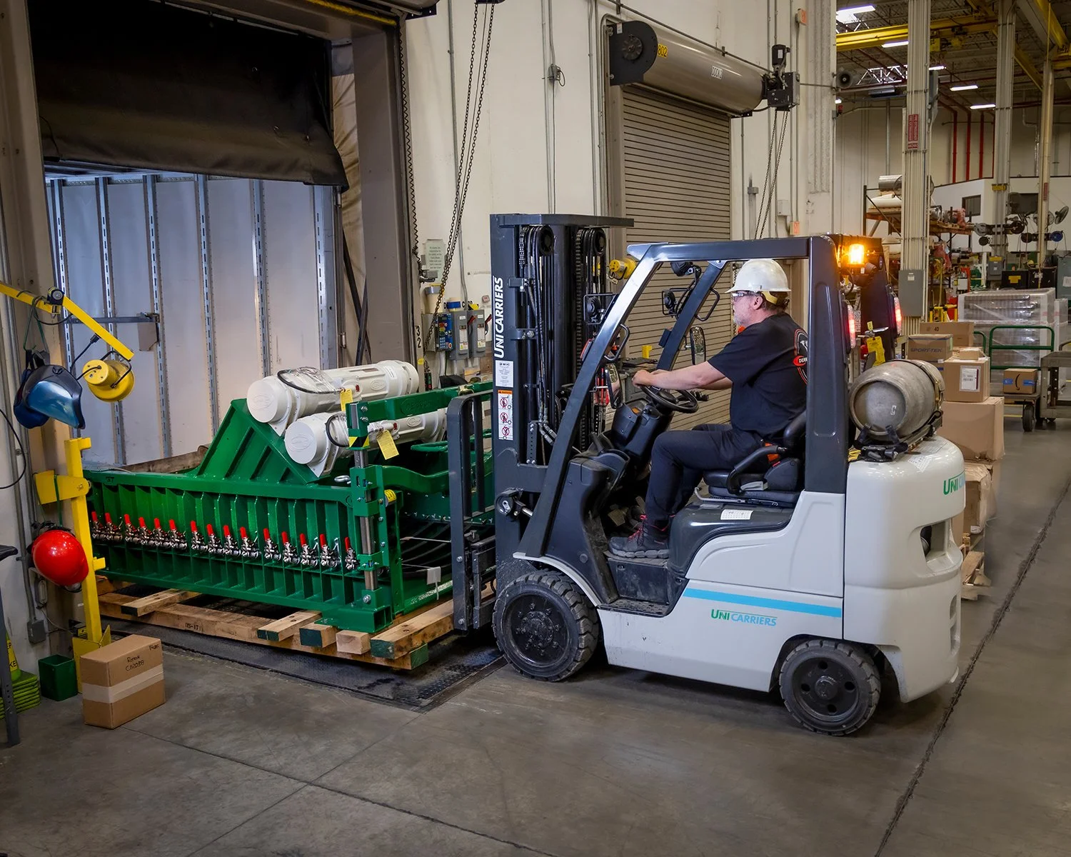 Forklift Operator Moving Equipment in Industrial Manufacturing Facility