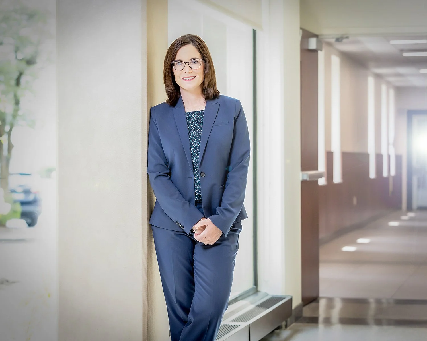Chicago Portrait Photography of a Female Executive Wearing Blue Suit and Glasses in a Long Hallway