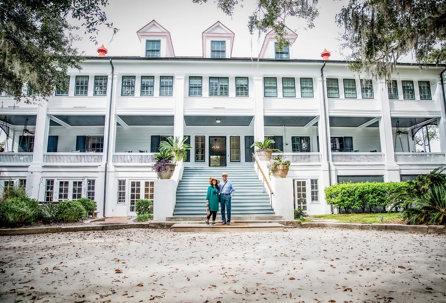Lifestyle Portrait of a Couple on Vacation in Front of a Large Mansion Built in 1900 that has been turned into an Inn.